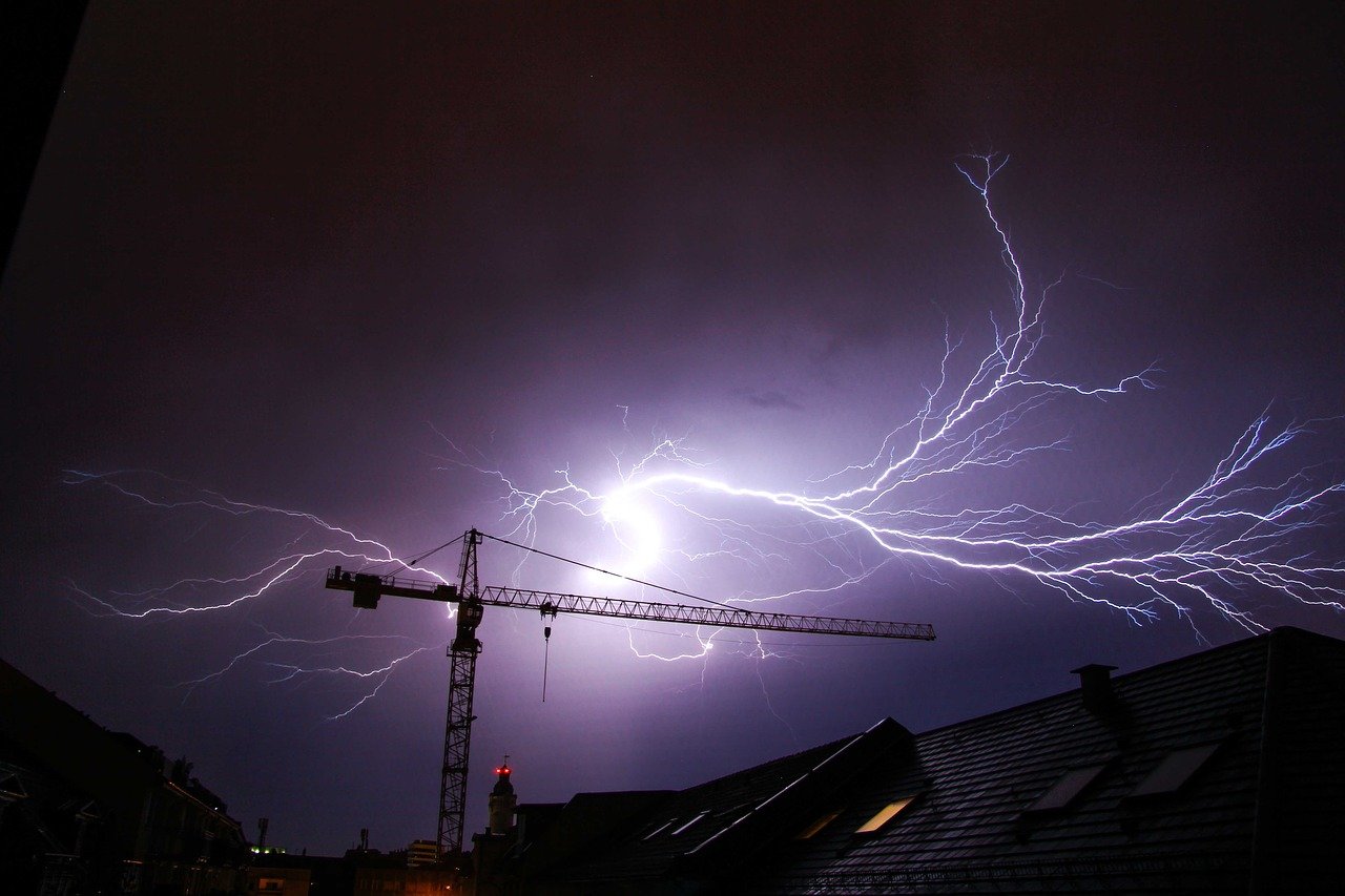 A lightning strike illuminates a stormy night sky