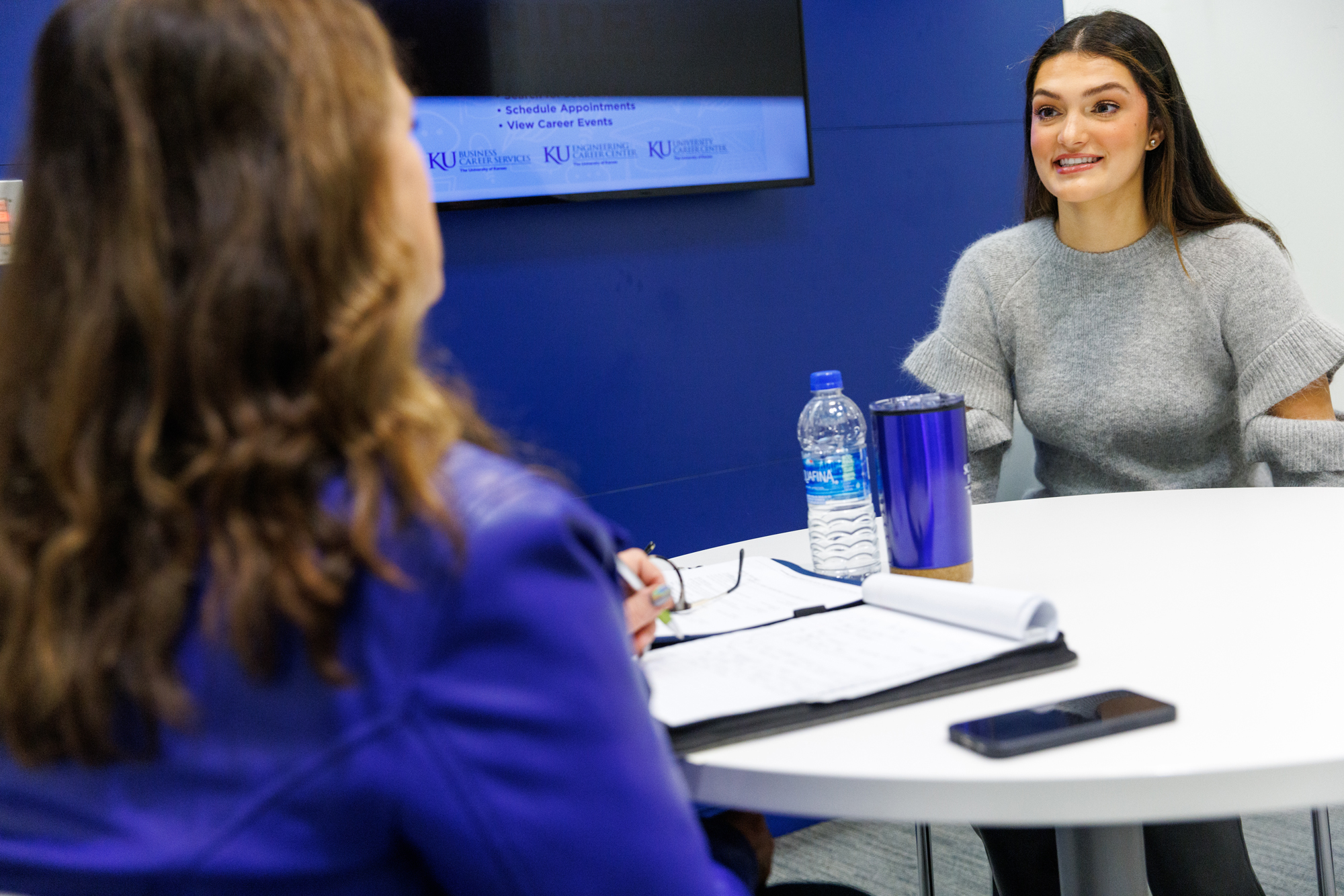 A student meets with an employer for a mock interview.