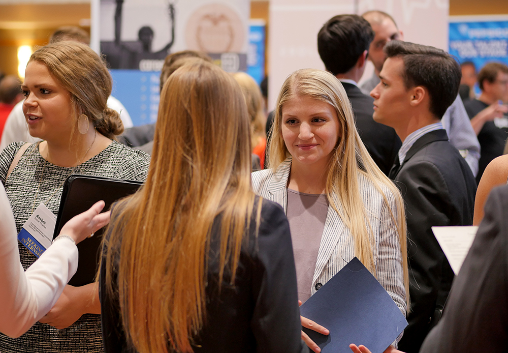 Students speak to recruiters at a previous Business Career Fair