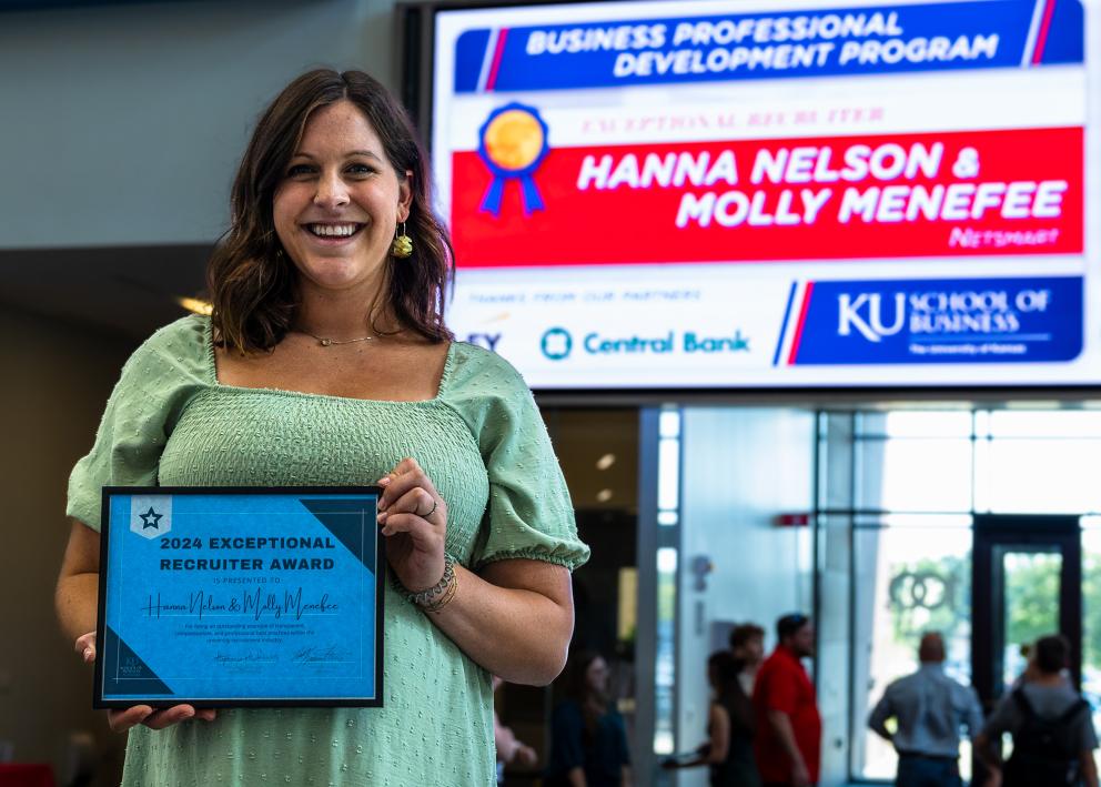 A woman holds the 2024 Exceptional Recruiter Award from the Business Professional Development Program