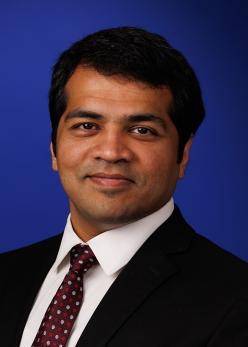 Photo of Karthik Srinivasan against a blue background