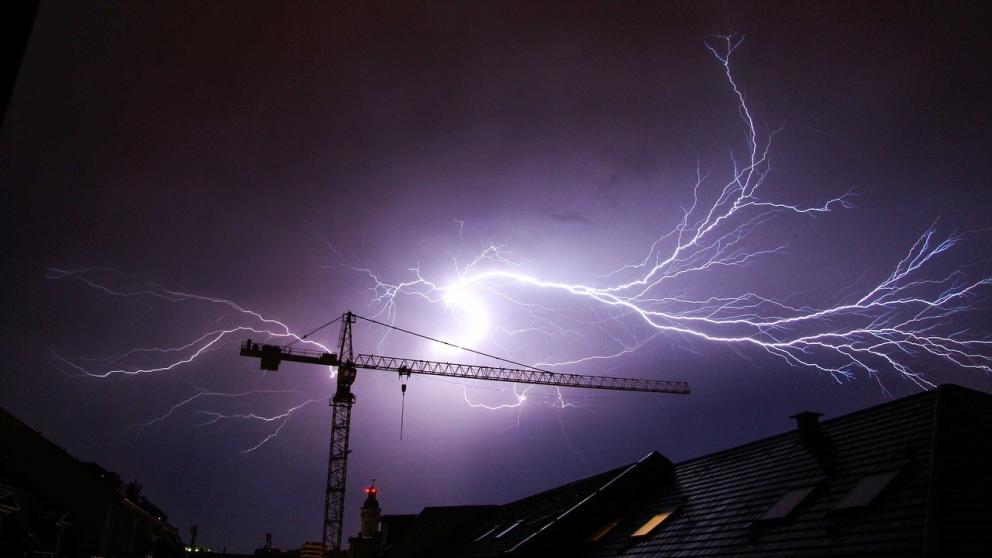 A lighning strike illuminates a stormy night sky